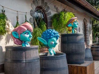 Drei Yomis in der Attraktion Josefinas kaiserliche Zauberreise im Europa-Park blicken aus Weinfässern heraus.