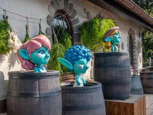 Drei Yomis in der Attraktion Josefinas kaiserliche Zauberreise im Europa-Park blicken aus Weinfässern heraus.