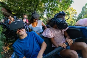 Fahrgäste auf Alpenexpress Coastiality, vier Personen mit VR-Brillen in grüner Landschaft.