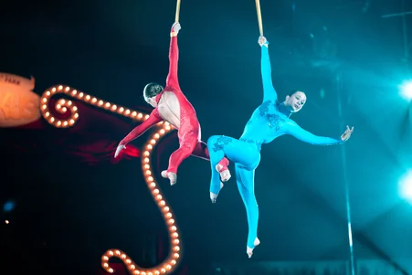 Zwei junge Artistinnen turnen Luftakrobatik an hängenden Seilen.