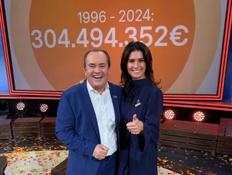 Wolfram Kons und Miriam Mack (von links) stehen gemeinsam vor einer großen Anzeige mit den, im Rahmen des RTL-Spendenmarathons von 1996 bis 2024, gespendeten 304.494.352 €.
