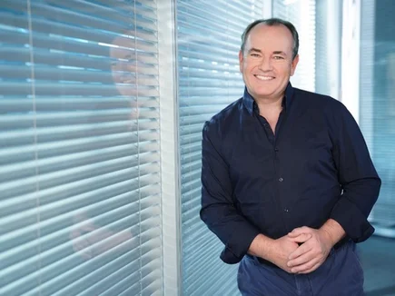 Wolfram Kons lehnt entspannt an einer Scheibe.