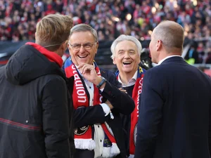 Roland und Jürgen Mack gemeinsam mit Jochen Saier und Oliver Leki, Vorstand des SC Freiburg, auf dem Spielfeld im Europa-Park Stadion in Freiburg.