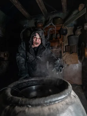 Kapuzen-Darsteller vor Fass in der Scare Attraction Tarot House.