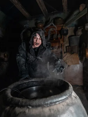 Kapuzen-Darsteller vor Fass in der Scare Attraction Tarot House.