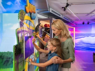 Eine Mutter und ihre Tochter erstellen gemeinsam einen JUNIOR CLUB Account am JUNIOR CLUB Terminal im Shop "Ed & Eddas Fundus".