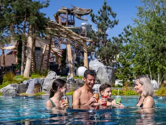 Familie erfrischt sich an einem köstlichen Getränk an der Svømme-Bar im Außenpool Svømmepøl in Rulantica.