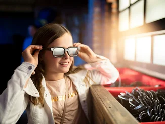 Mädchen setzt eine 3D-Brille in der Attraktion GRAND PRIX EDventure im Europa-Park auf. 