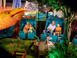 Familie sitzt in der Attraktion Madame Freudenreich Curiosités im Europa-Park.