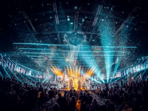 Sehr viele Künstler und Artisten sind auf der Bühne der Europa-Park Arena zu sehen. In der Luft schwebt überall Konfetti.