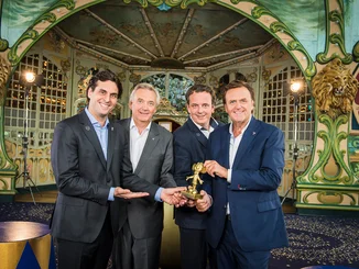 Thomas Mack, Jürgen Mack, Michael Mack und Roland Mack halten eine kleine, goldene Trophäe in der Hand, die aussieht, wie eine Maus.