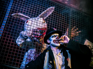 Darsteller mit Zigarre und Darsteller im Wakala Kostüm in Grims Funhouse, einer Scare Attraction von Traumatica.
