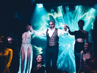 Männer und Frauen vor einem Portal.