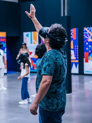 Mann mit VR-Headset streckt die Hand aus.