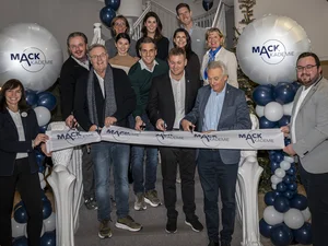 Familie Mack steht auf der Treppe der MACK Akademie und durchtrennt ein Band zur Eröffnung.
