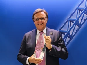 Roland Mack hält eine IAAPA-Auszeichnung, einen internationalen Preis der Freizeitparkbranche, in den Händen.