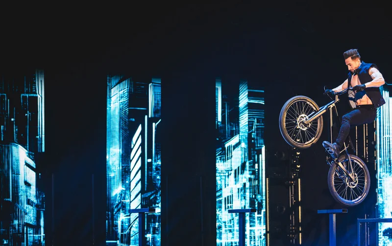 Ein Artist der Europa-Park Dinner-Show wagt einen gefährlichen Sprung auf einem BMX-Rad.