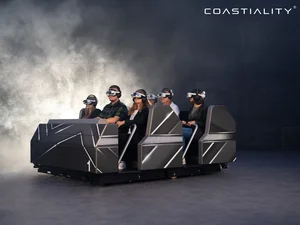 Fahrgäste sitzen in dem Flowryde, ausgestattet mit VR-Headsets.