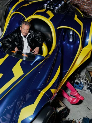 Michael Mack sitzt in einem Rennauto im Wartebereich der Attraktion GRAND PRIX EDventure.