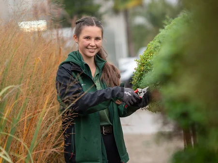 Eine Mitarbeiterin der Gärtnerei im Europa-Park Erlebnis-Resort bei der Arbeit mit unterschiedlichen Pflanzen.