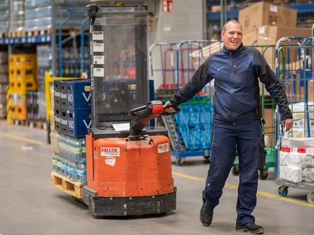 Ein Mitarbeiter der Logistik im Europa-Park Erlebnis-Resort. Er befördert Ware mittels eines Flurförderfahrzeugs.