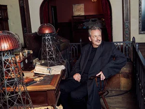 Michael Mack am Schreibtisch von Nikola Tesla, darauf befinden sich zwei Wardenclyffe Tower.