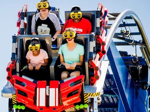 Fahrgäste der Attraktion The Great LEGO® Race im LEGOLAND Florida, ausgestattet mit gelben VR-Headsets mit überdimensional großen Augen.