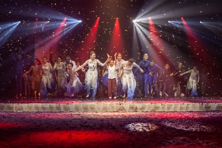 Les jeunes de la TALENT ACADEMY célèbrent sur scène un spectacle réussi.