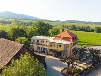 Außenansicht des Restaurant Amitié – La Cuisine du Château mit idyllischem Panorama.
