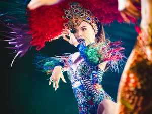 Eine Tänzerin der Europa-Park Dinner-Show mit opulentem Kopfschmuck und bunter Kleidung.